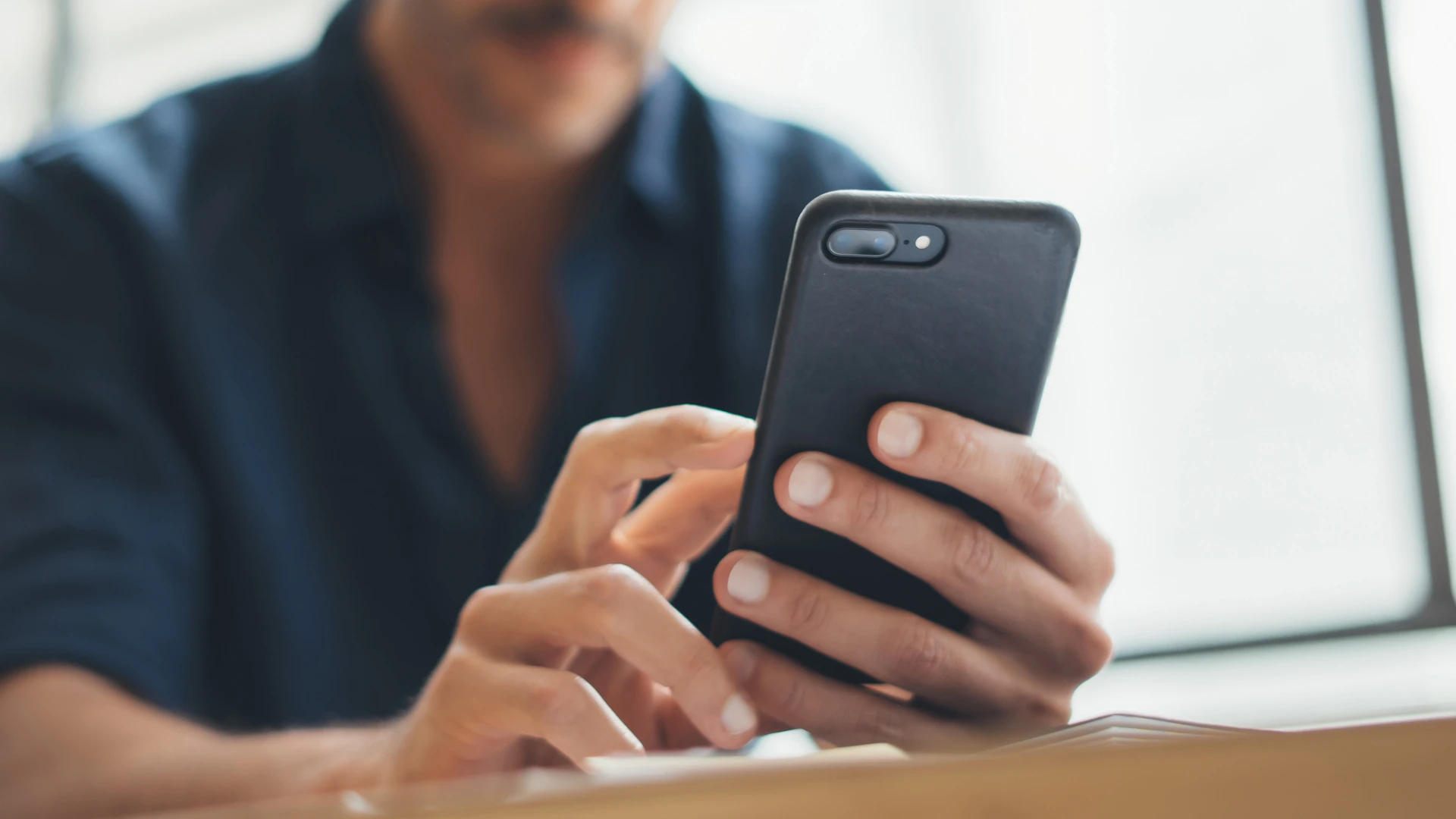 Mann bedient sein Smartphone.