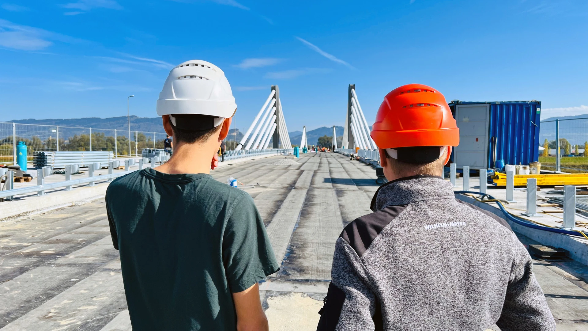 Ein Bauleiter und ein Arbeiter von Wilhelm-Mayer besichtigen die Baustelle der neuen Rheinbrücke zwischen Hard und Fußach.