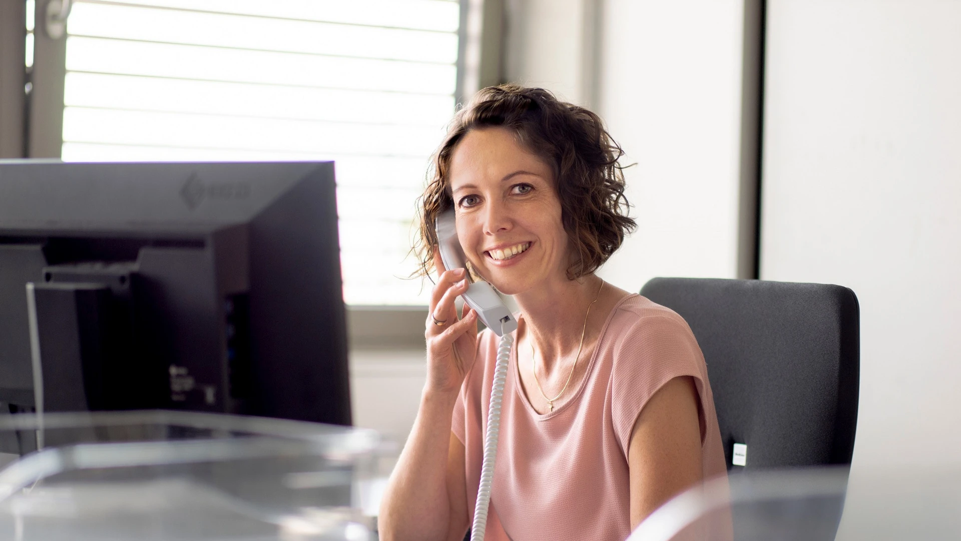 Mitarbeiterin von Wilhelm und Mayer telefoniert und lächelt