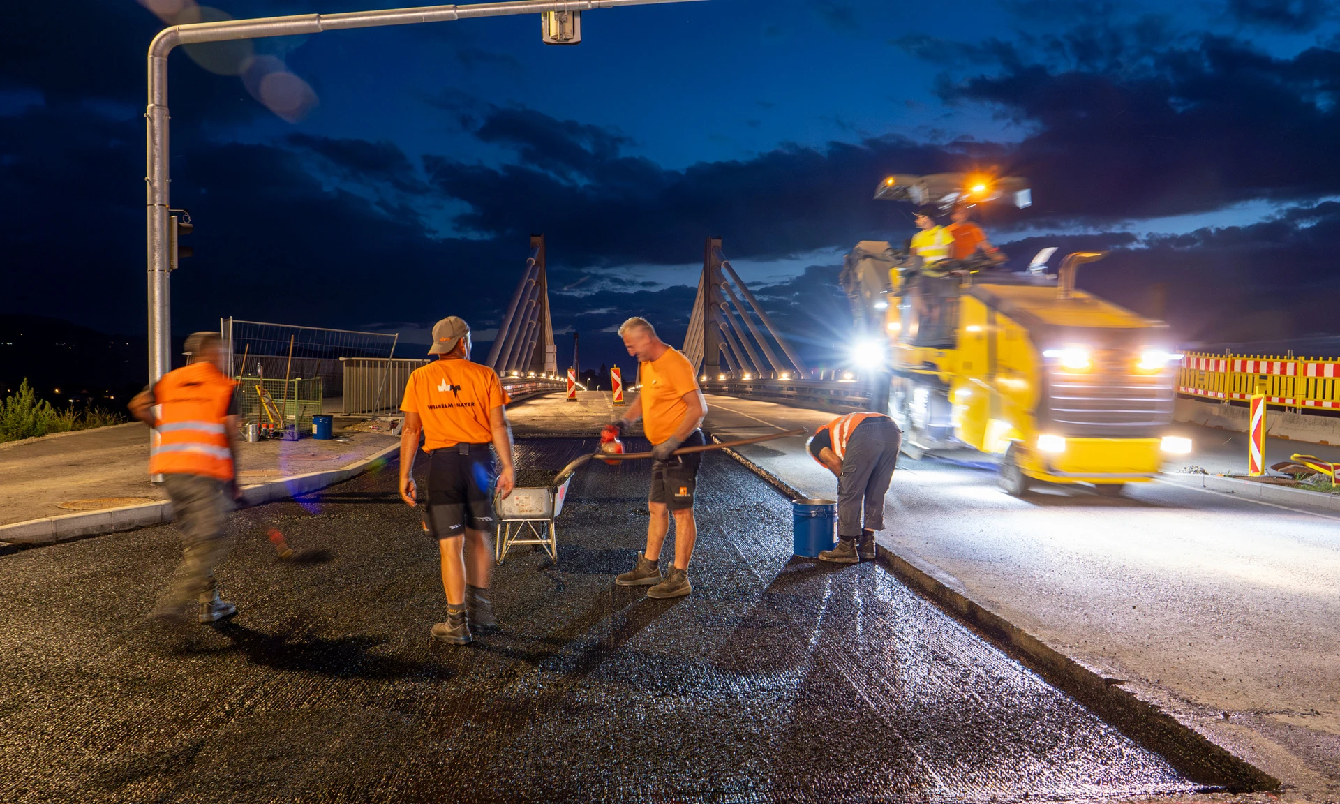 Arbeiter von Wilhelm-Mayer asphaltieren die Auffahrt zur Rheinbrücke zwischen Hard und Fußach.