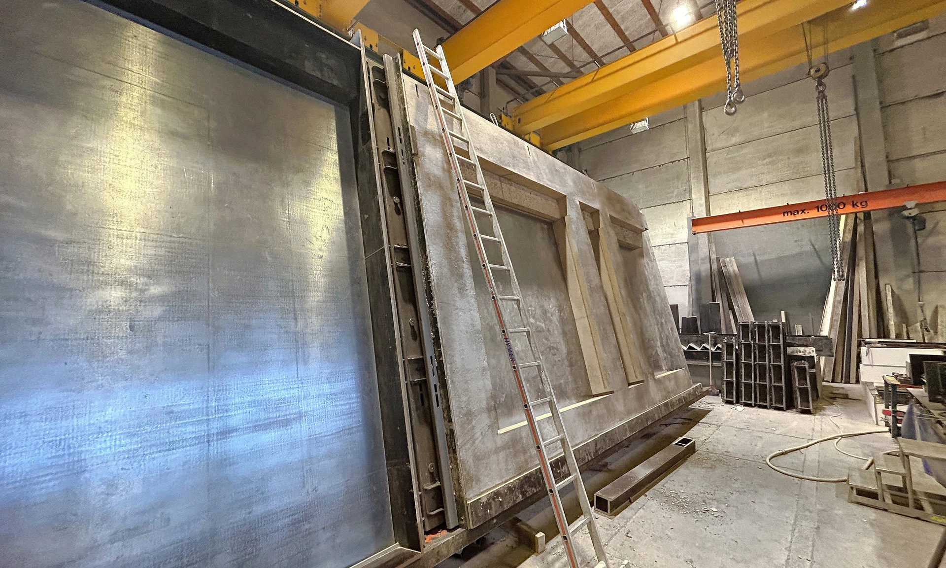 In der Produktionshalle des Fertigteilwerks von Wilhelm-Mayer steht ein großes Fassadenelement aus Beton zur Weiterverarbeitung bereit.