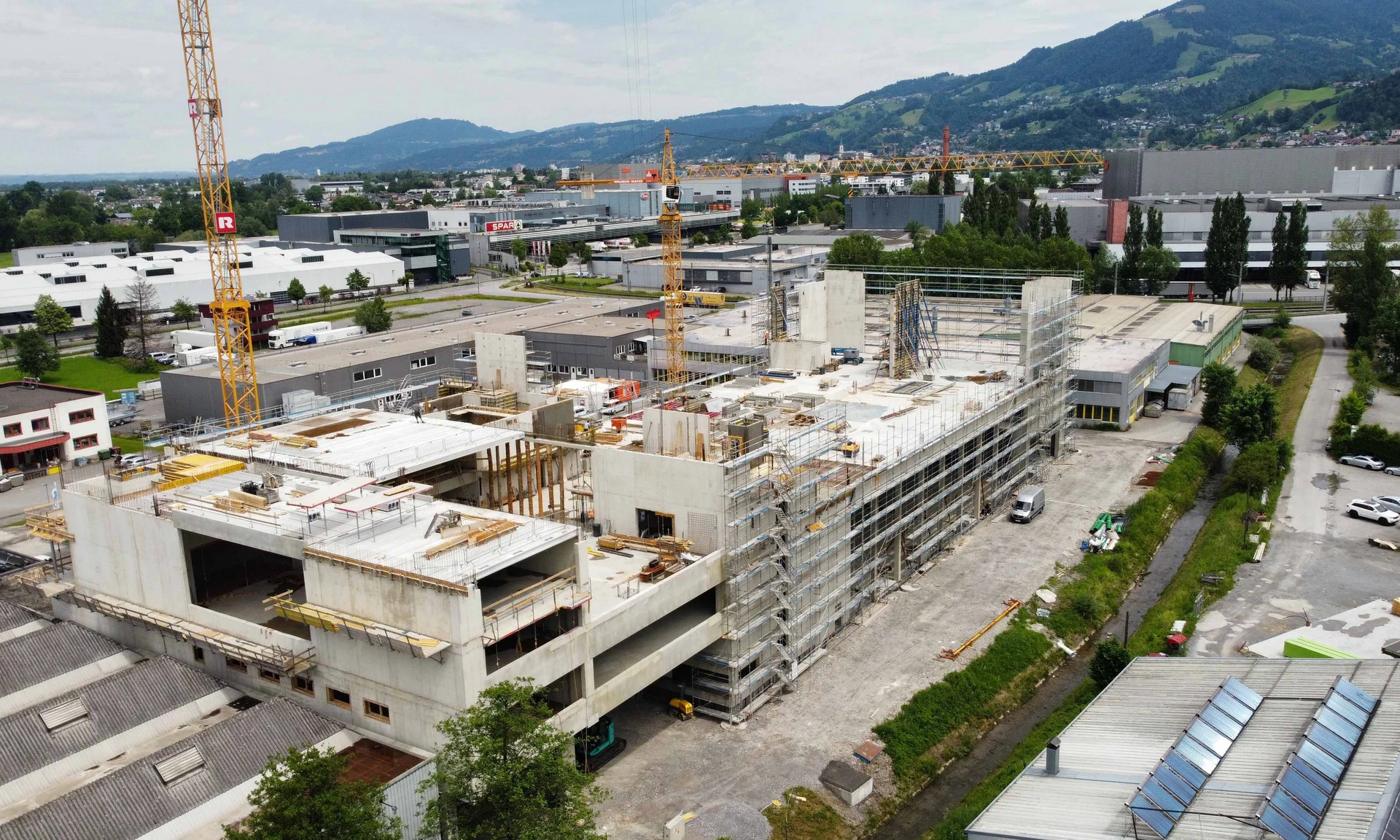 Drohnenaufnahme von der Bauphase Betriebserweiterung Fahrzeugbau Wohlgenannt in Dornbirn.