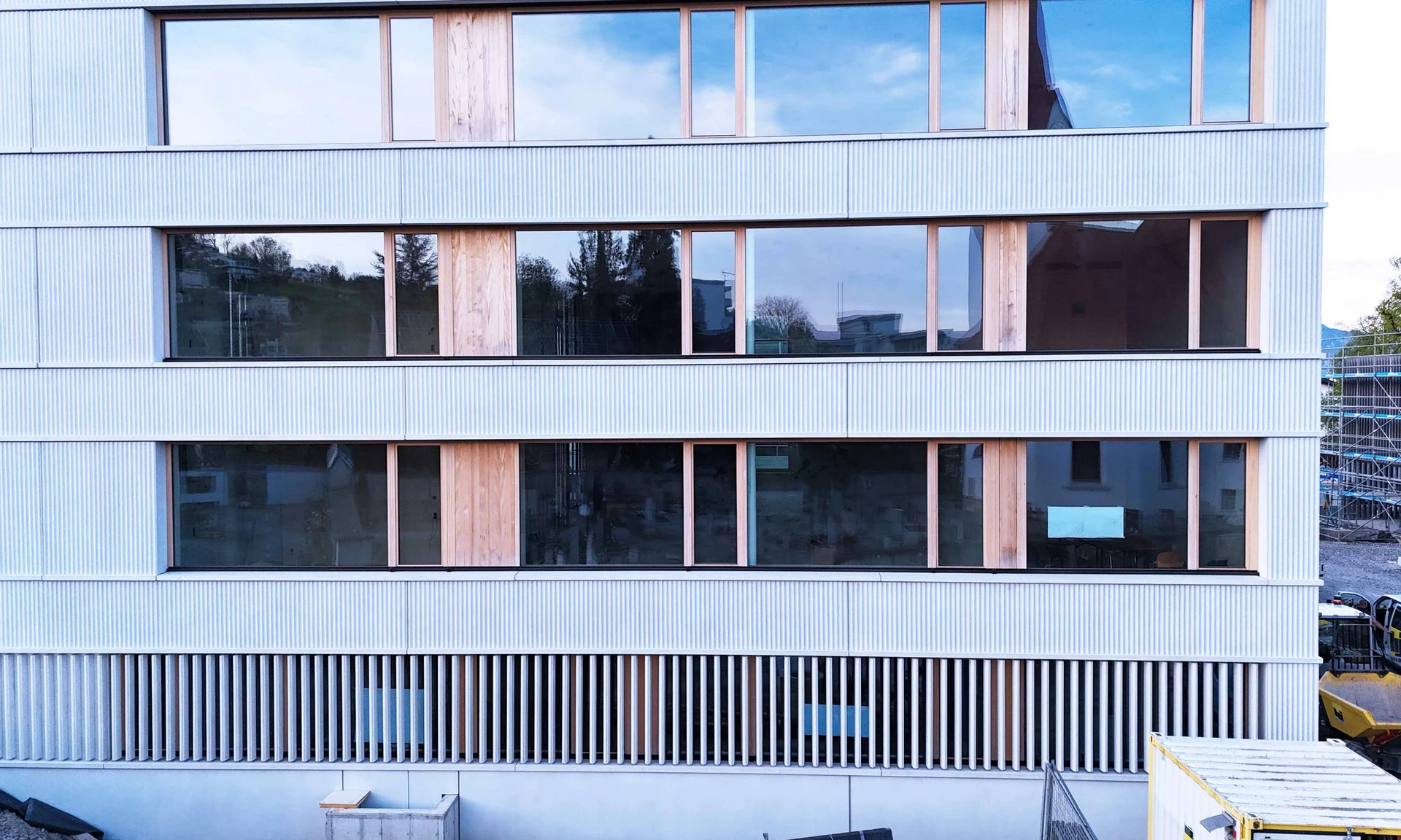 Foto von der Fassade des neuen Kindergartens in Dornbirn-Haselstauden, welche aus über 370 Betonfertigteilelementen von Wilhelm+Mayer besteht.