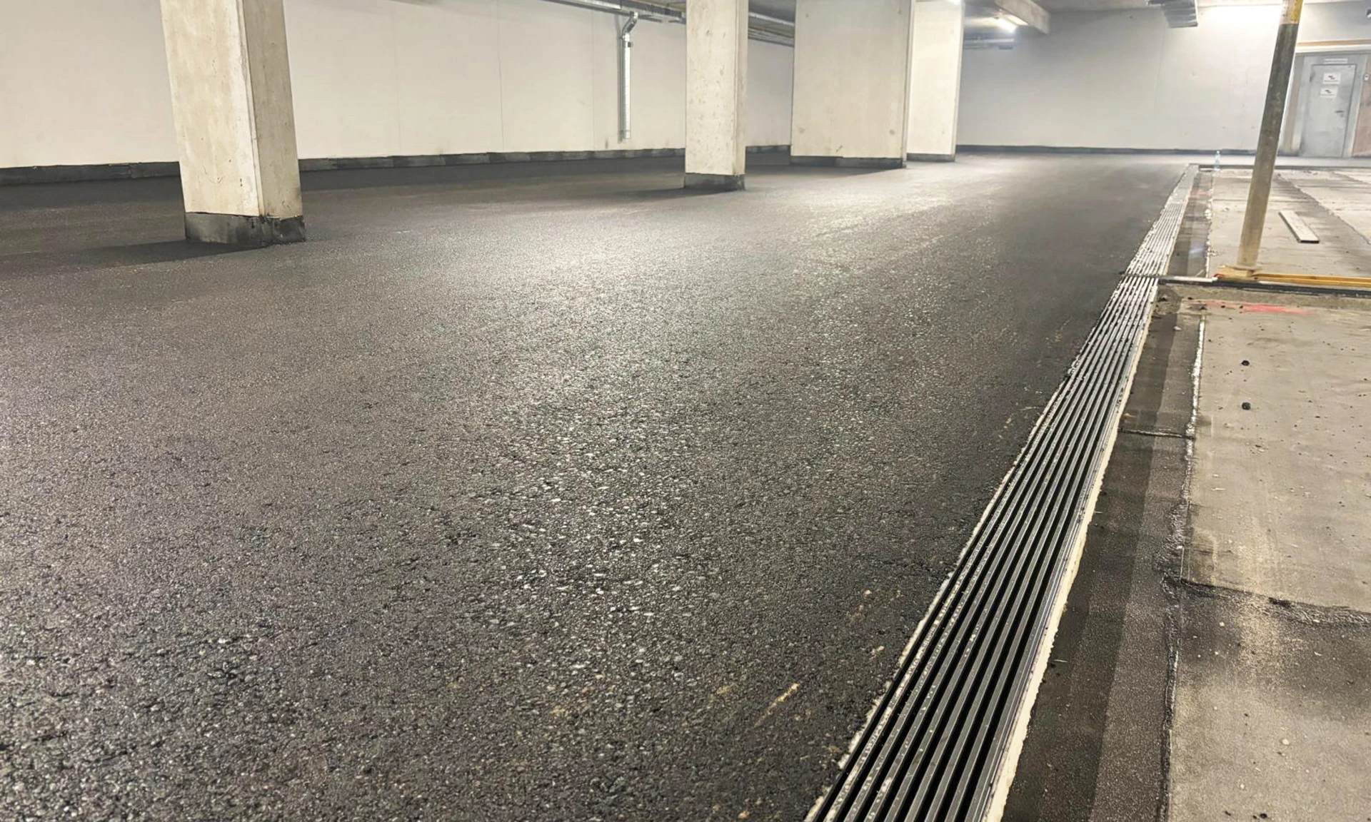 Detailaufnahme von neuem Asphaltbelag in Tiefgarage bei Neubau Am Garnmarkt in Götzis.