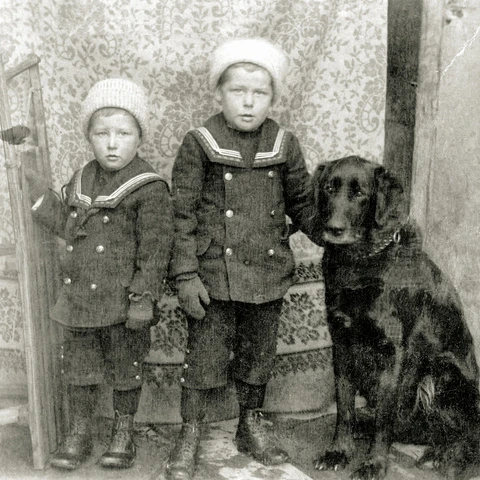 Zwei Kinder (Georg und Hugo Wilhelm) mit schwarzem Hund. 