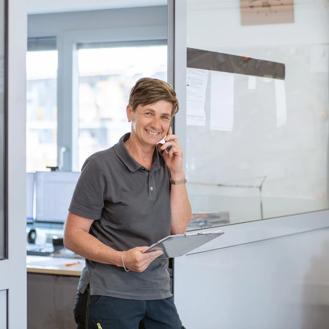 Mitarbeiterin am Bauhof von Wilhelm-Mayer in Klaus telefoniert und bereitet ein Angebot vor.