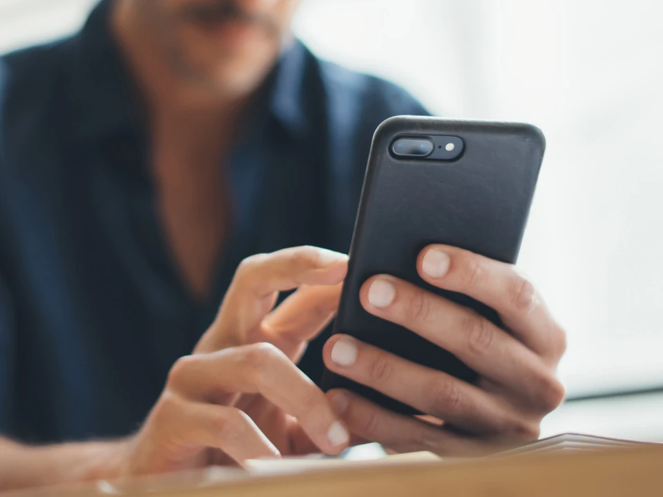 Mann bedient sein Smartphone.