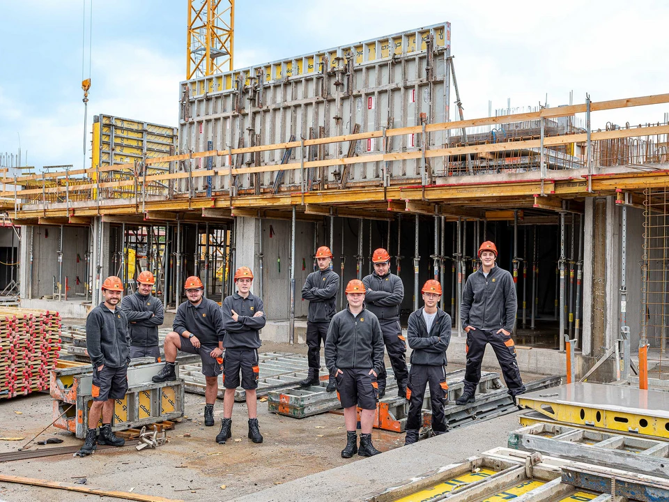 Teamfoto von Lehrlingen auf einer Baustelle von Wilhelm+Mayer in Götzis.